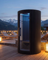 Sanctuary Solo Infrarot-Sauna auf einer luxuriösen Hotel-Spa-Terrasse in der Abenddämmerung mit Alpenpanorama