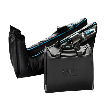 Aerify ALPHAS Boots, Manschetten neben der schwarzen Reisetasche auf weißem Hintergrund