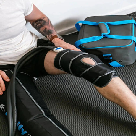 Aerify Knee/Elbow Attachment für Cryoboots am Knie eines sitzenden Mannes, Kühltasche im Hintergrund