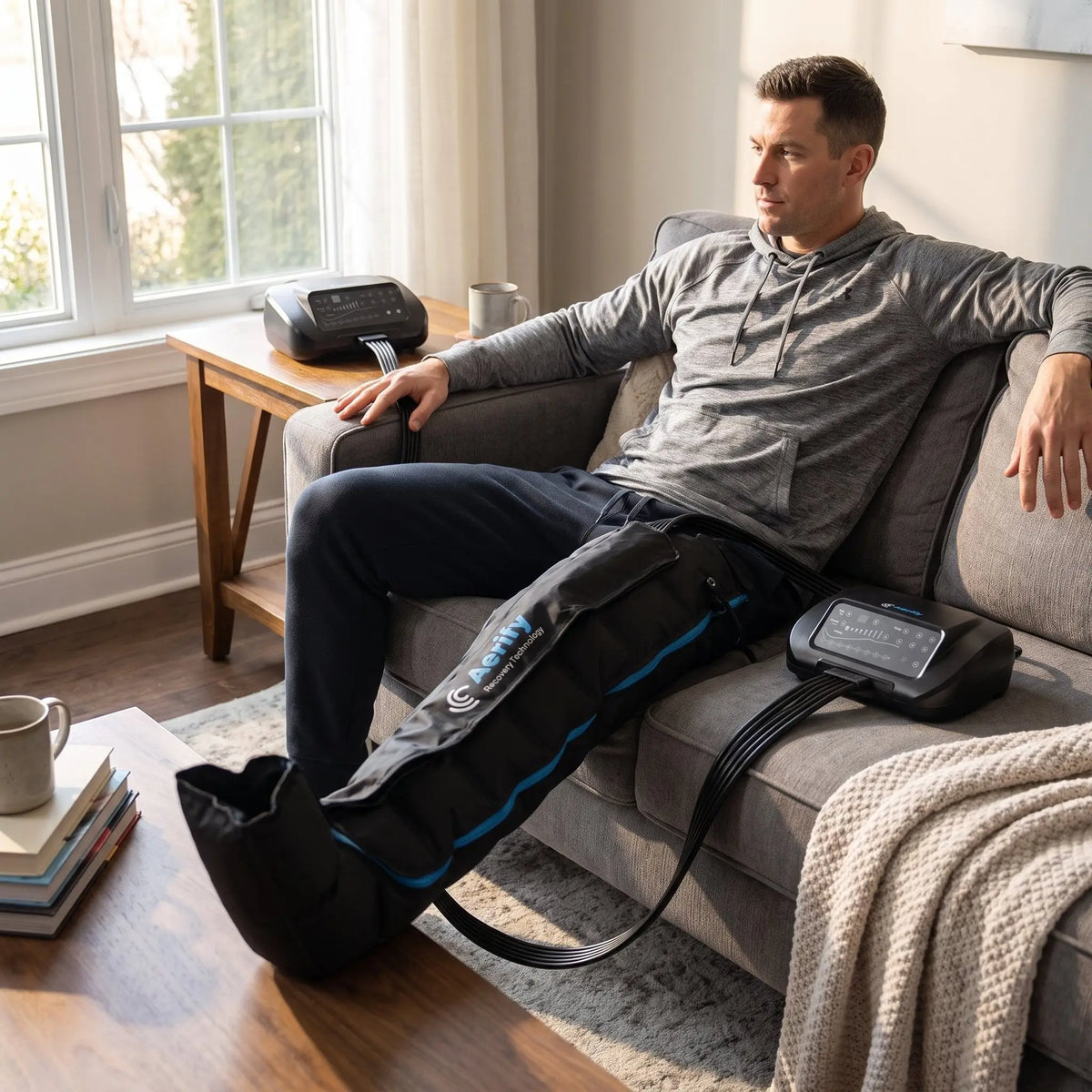 Aerify Standard Recovery System mit Pants im Einsatz: Sportler entspannt nach dem Training auf dem Sofa