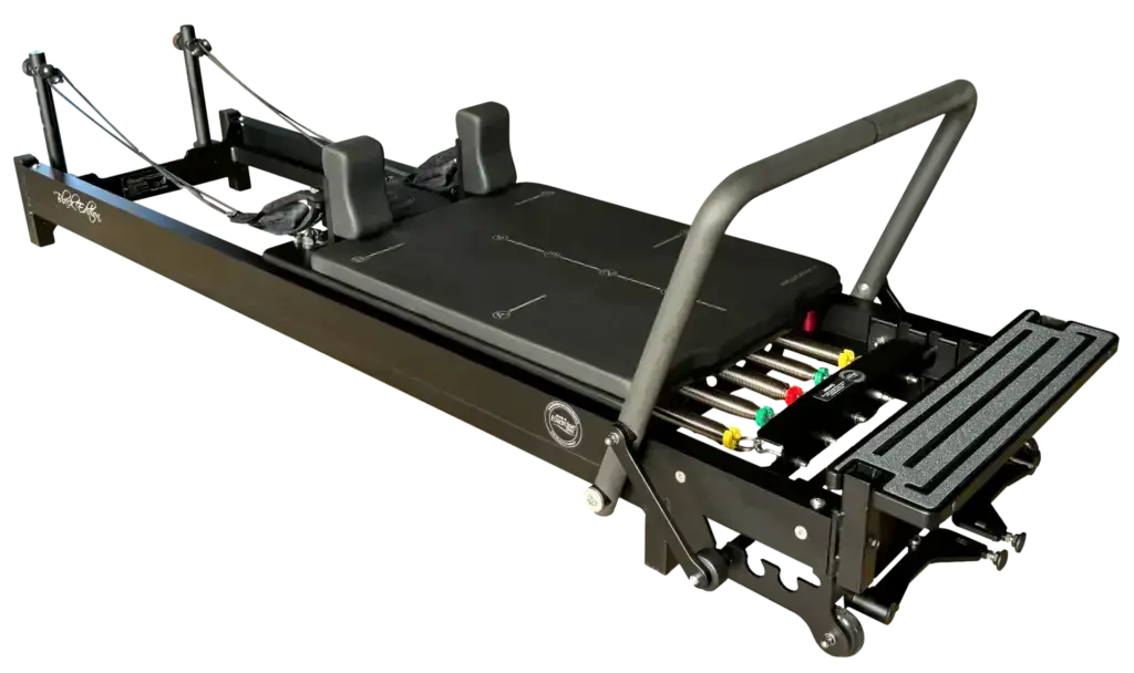 Body & Exercise Reformer Black Edition in Schrägansicht mit Fußstange, farbigen Federn und Schulterstützen in Schwarz