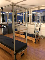 Body & Exercise Reformer Combo aus Buchenholz, Detail des Rahmens mit Schlaufen in einem Studio am Fenster