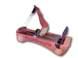 Body & Exercise Reformer Kid in Rosa mit Kind bei einer Übung an den Schlaufen vor schwarzem Hintergrund