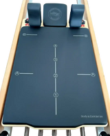 Body & Exercise Reformer Studio P001 aus Buchenholz, Detail der blauen Matte mit Markierungen und Kopfstütze