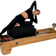 Body & Exercise Reformer Studio P001 aus Buchenholz, Frau bei einer Übung auf dem Reformer, schwarzer Hintergrund
