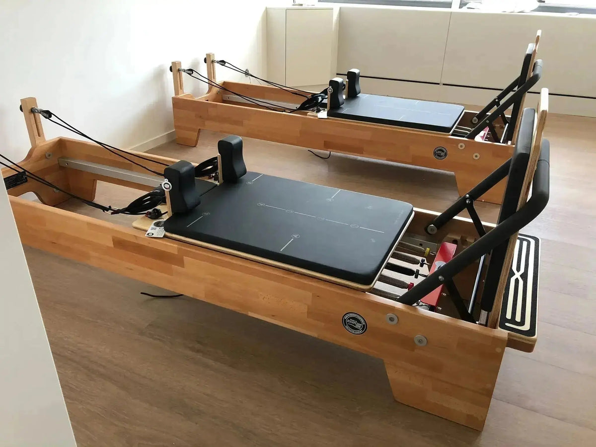 Body & Exercise Reformer Studio P001 aus Buchenholz, zwei Reformer nebeneinander in einem Raum