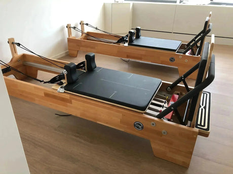 Body & Exercise Reformer Studio P001 aus Buchenholz, zwei Reformer nebeneinander in einem Raum