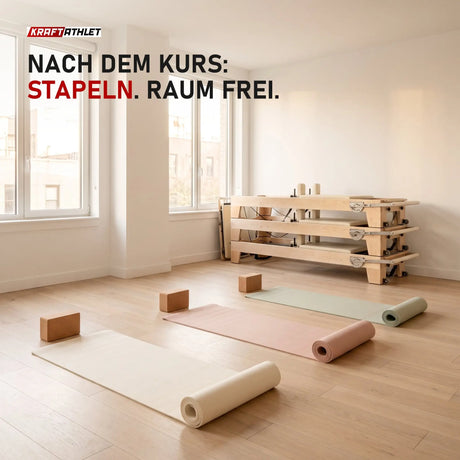 Drei gestapelte Elina Pilates Elite Reformer aus Ahornholz in der Ecke eines Studios, davor Yogamatten