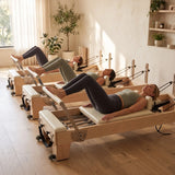 Kleingruppe trainiert auf drei Elina Pilates Elite Reformern aus Ahornholz in einem Boutique-Studio