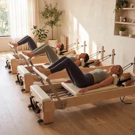 Kleingruppe trainiert auf drei Elina Pilates Elite Reformern aus Ahornholz in einem Boutique-Studio