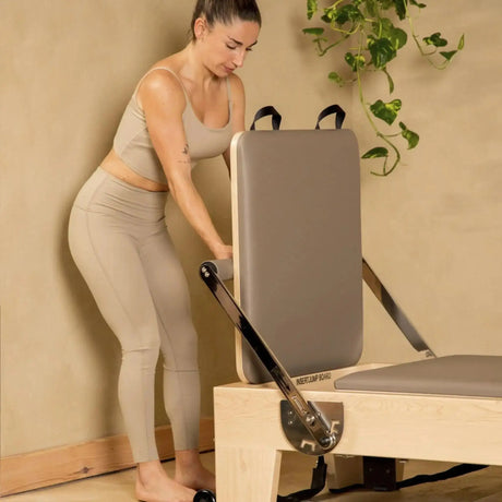 Frau stellt die Sitzbox am Elina Pilates Elite Reformer auf