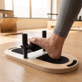 Nackter Fuß auf dem Elina Pilates Foot Corrector, Ferse auf dem Polster, Fußgewölbe über der Stange