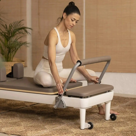 Frau stellt die Fußstange am Elina Pilates Nubium Reformer ein