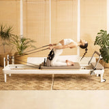 Frau trainiert mit den Seilschlaufen auf dem Elina Pilates Nubium Reformer