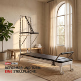 Elina Pilates Nubium Reformer mit Edelstahl-Turm und schwarzem Polster in einem hellen Boutique-Studio