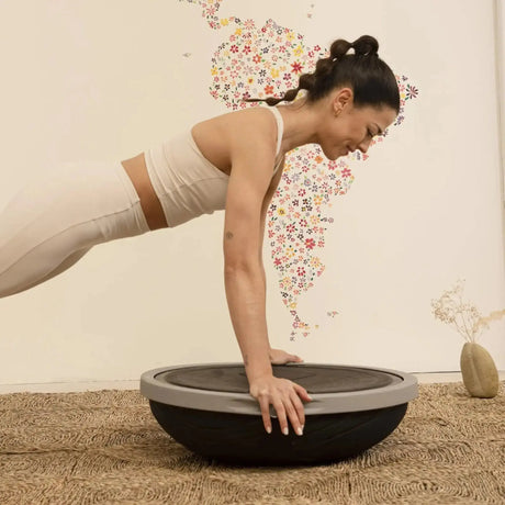 Elina Pilates Air Step Balance Station Pro Balancetrainer, Frau stützt sich im Liegestütz auf die Basis