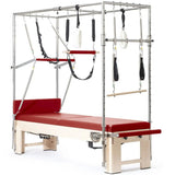 Elina Pilates Cadillac Elite Reformer aus Rock-Ahorn – Schrägansicht mit Ahorngestell und Polstern in Rot