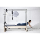 Elina Pilates Cadillac Elite Reformer aus Rock-Ahorn – Frau in Bauchlage, Seitenansicht im Studio