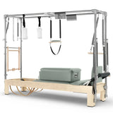 Elina Pilates Cadillac Reformer aus Ahornholz, Seitenansicht mit Polstern in Grün und Trapez-Rahmen aus Aluminium