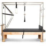 Elina Pilates Cadillac Reformer aus Rock-Ahorn – Seitenansicht mit Trapezrahmen und schwarzem Polster