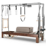 Elina Pilates Cadillac Reformer aus Walnussholz – Schrägansicht mit Stahlrahmen und Polstern in Eisblau
