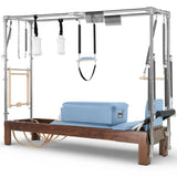 Elina Pilates Cadillac Reformer aus Walnussholz – Schrägansicht mit Stahlrahmen und Polstern in Ozeanblau