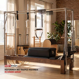 Elina Pilates Cadillac Reformer aus Walnussholz in einem hellen Pilates-Studio mit Holz und Leinen