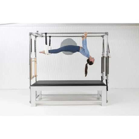 Elina Pilates Classic Cadillac aus Aluminium – Frau hängt in den Trapez-Schlaufen im Studio