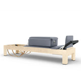 Elina Pilates Classic Reformer aus Ahornholz mit grauem Polster und Sitzbox, Schrägansicht