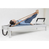 Elina Pilates Classic Reformer aus Aluminium, Frau trainiert in Rückenlage mit Schlaufen