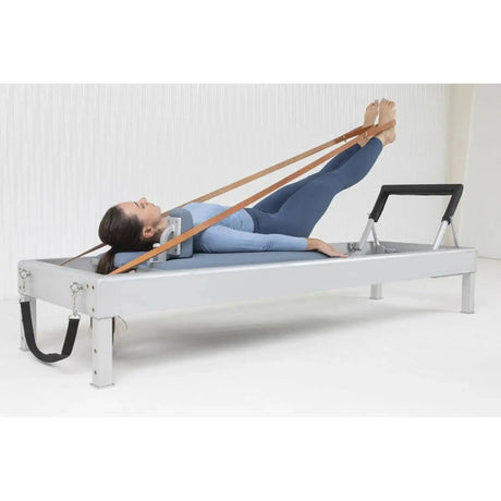 Elina Pilates Classic Reformer aus Aluminium, Frau trainiert in Rückenlage mit Schlaufen