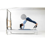 Elina Pilates Classic Reformer mit Tower aus Aluminium – Frau in Pike-Position auf dem Schlitten im Studio