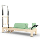Elina Pilates Classic Reformer mit Tower aus Ahornholz mit Polstern in Eukalyptus, Seitenansicht vor weißem Hintergrund