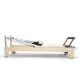 Elina Pilates Club Reformer aus Ahornholz in Elfenbein, Seitenansicht mit Federn und Fußstange