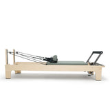 Elina Pilates Club Reformer aus Ahornholz in Grün, Seitenansicht mit Federn und Fußstange