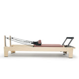 Elina Pilates Club Reformer aus Ahornholz in Mokka, Seitenansicht mit Federn und Fußstange