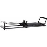 Elina Pilates Domo Reformer aus Aluminium in Schrägansicht mit Schlitten, Schulterstützen und Fußstange