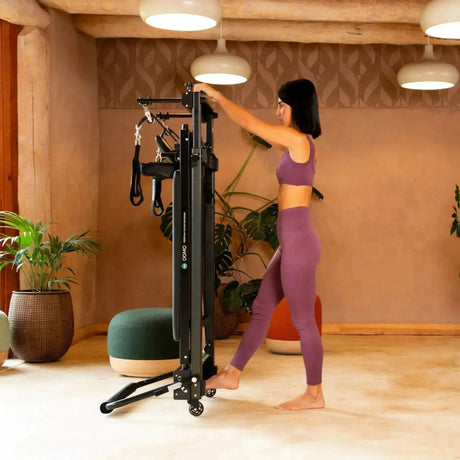 Elina Pilates Domo Reformer aus Aluminium im Studio, eine Frau stellt das Gerät senkrecht auf