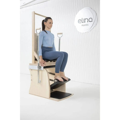 Elina Pilates Electric Chair Kombi-Wunda aus Ahornholz: Frau sitzt auf dem Chair und drückt das Pedal mit einem Fuß
