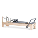 Elina Pilates Elite Advanced Reformer aus Ahornholz mit grauem Polster, Schrägansicht