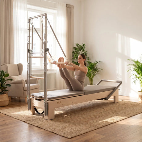Elina Pilates Elite Advanced Reformer mit Tower im Einsatz: Frau trainiert morgens im Wohnzimmer