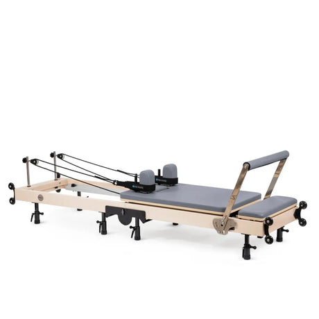 Elina Pilates Klappbarer Reformer aus Ahornholz mit grauem Polster, Seitenansicht aufgeklappt mit Seilzügen und Fußstange