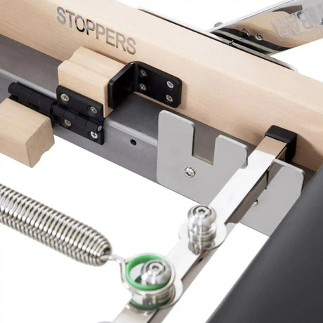 Elina Pilates Lignum Reformer mit Tower aus Holz, Detail der Federhalterung mit Stopper am Schlitten