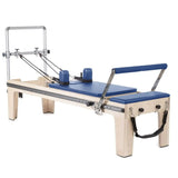 Elina Pilates Master Instructor Physio Reformer aus Ahornholz mit blauen Polstern, Seitenansicht auf Weiß