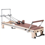 Elina Pilates Master Instructor Reformer aus Ahornholz – Schrägansicht mit Polstern in Altrosa, freigestellt vor weißem Hintergrund