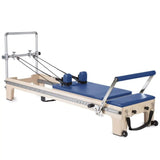 Elina Pilates Master Instructor Reformer aus Ahornholz – Schrägansicht mit Polstern in Blau, freigestellt vor weißem Hintergrund