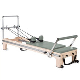 Elina Pilates Master Instructor Reformer aus Ahornholz – Schrägansicht mit Polstern in Eukalyptus, freigestellt vor weißem Hintergrund