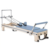 Elina Pilates Master Instructor Reformer aus Ahornholz – Schrägansicht mit Polstern in Ozeanblau, freigestellt vor weißem Hintergrund