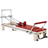 Elina Pilates Master Instructor Reformer aus Ahornholz – Schrägansicht mit Polstern in Rot, freigestellt vor weißem Hintergrund