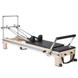 Elina Pilates Master Instructor Reformer aus Ahornholz – Schrägansicht mit Polstern in Schwarz, freigestellt vor weißem Hintergrund